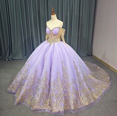 Experience ultimate luxury with our exquisite Princess Purple and Gold Quinceañera Ball Gown. This regal dress boasts a sweetheart front bodice and a gold-trimmed illusion corset, adorned with off-the-shoulder beaded gold long sleeves. The gathered full skirt is elegantly trimmed in gold and features a train, while the lace-up back allows for a customizable fit. Elevate your event with this exclusive and sophisticated masterpiece. material: organza, glitter tulle, lace type: a line ball gown style: formals color as shown built in bra sweetheart neckline train as shown lace up back Quince Dresses Purple And Gold, Quinceanera Dresses Purple And Gold, Purple And Gold Dress Gowns, Purple And Gold Quinceanera Dresses, Rapunzel Quinceanera, Tangled Quince, Ballroom Extravaganza