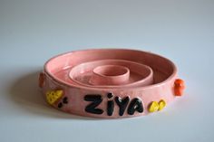 a pink ceramic bowl with the word avazi written in black on it's side