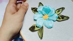 someone is working on an embroidered flower