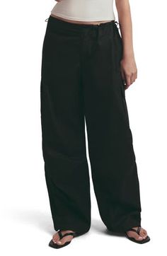 Draw inspiration from the baggy, low-slung fits of Y2K in these cotton cargo pants that cinch with drawcord toggles along the waistband. 31" inseam; 22" leg opening; 10 3/4" front rise; 12" back rise Zip fly with button closure; drawcord-toggle waist Front slant pockets; back patch pockets; cargo flap-patch pockets 100% cotton Machine wash, line dry Imported Black Cotton Parachute Pants With Drawstring, Sporty Cotton Cargo Pants For Work, Sporty Cotton Parachute Pants For Work, Sporty Cotton Wide-leg Cargo Pants, Sporty Wide-leg Cotton Cargo Pants, Cotton Cargo Pants, Favorite Daughter, The Low, Back Patch