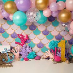 there are many balloons and decorations on the wall in front of this party backdrops