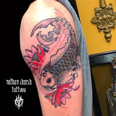 a man with a tattoo on his arm has a koi fish and red flowers