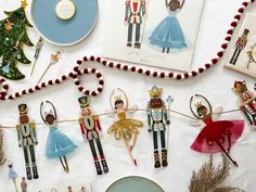 christmas decorations and ornaments are laid out on a white tablecloth, including nutcrackers