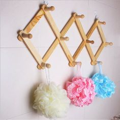 three pom poms hanging on the wall next to each other with wooden pegs