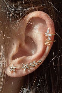 a close up of a person's ear with two small flowers on the side