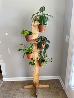 a wooden plant stand with potted plants on it