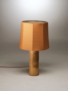 a table lamp with a brown shade on it and a cord attached to the base