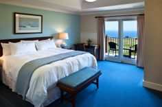 a bedroom with blue carpet and white bedding