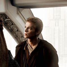 a young man standing in front of a window next to a giraffe