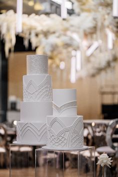 three tiered wedding cake sitting on top of a table