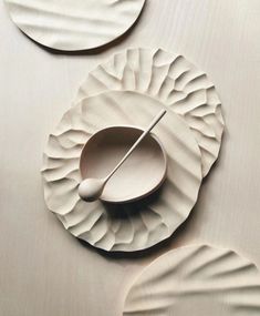 three white plates with spoons on top of them