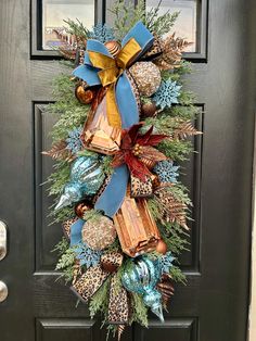 a christmas wreath on the front door with presents hanging from it's bow and decorations