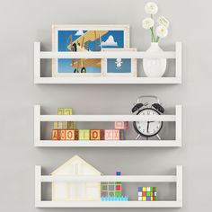 two white shelves with pictures and toys on them, one has an alarm clock in the middle