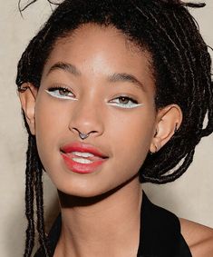 a close up of a person with dreadlocks on her head and blue eyes