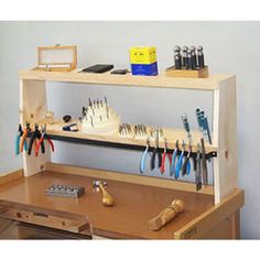 a wooden desk with various tools on it and a shelf holding pens, pencils, scissors and other office supplies