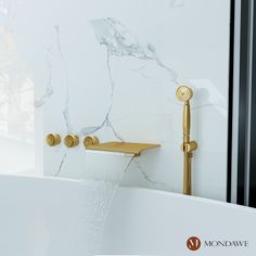 a white bath tub sitting under a faucet next to a wall mounted shower head