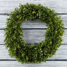 a green wreath sitting on top of a wooden table