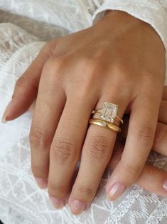 a close up of a person's hand with two rings on their wedding day