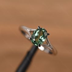 It is a green sapphire ring. The main stone is 6mm*8mm oval cut, weight about 1.75 carats. The basic metal is sterling silver and plated with rhodium. To change the metal to a solid gold (white/rose) or platinum is also available, please ask for a quotation if you want. You can also go to my shop Home for more elegant rings: https://www.etsy.com/shop/godjewelry?ref=hdr_shop_menu More rings: https://www.etsy.com/shop/godjewelry?ref=l2-shop-header-avatar Customization is always welcome and please Lauren Johnson, Elegant Rings, Green Sapphire Ring, Green Sapphire, Star Ring, Split Shank, Elegant Ring, Ring Sterling Silver, Ring For Women