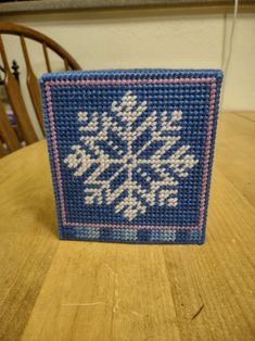 a blue and white snowflake sitting on top of a wooden table