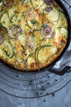 an omelet with zucchini and onions in a cast iron skillet