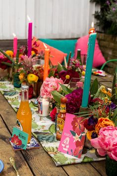 the table is set with flowers and candles for an outdoor dinner or brunch