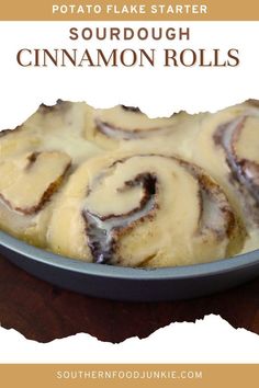 a pan filled with cinnamon rolls on top of a wooden table