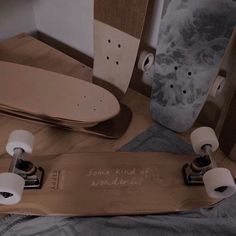 a skateboard with two rolls of toilet paper next to it on a bed in a room