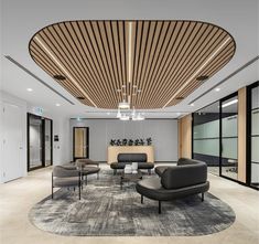 an office lobby with modern furniture and wood slats on the ceiling, along with large windows