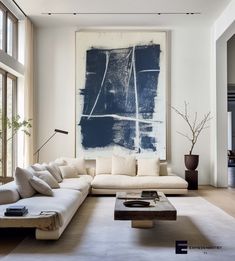 a living room filled with furniture and a large painting hanging on the wall above it