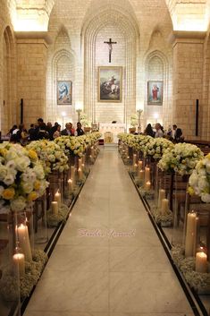 the aisle is lined with flowers and candles