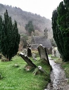 an old stone church surrounded by trees and grass