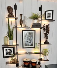 a living room filled with lots of shelves covered in pictures and plants on top of them