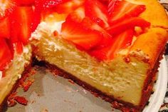 a cheesecake with strawberries is cut into slices