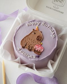 a purple birthday cake in a white box