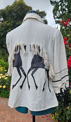 Stand out from the crowd wearing this unique handmade item! Good for any occasion - casual and relaxed or dressy. Inspired by bohemian and western styles. Order today and indulge yourself with our Wearable Art. Cool summer women's shirt. Made from linen, and decorated with different trims, has a unique leather horse design on the back and the sleeves. Handmade item. Off-white, natural linen color. Black horses and trim. Size medium. Great as a gift for her!   Birthday, anniversary, vacation, fam Western Style Embroidered Summer Tops, Embroidered Western Tops For Summer, Bohemian Cotton Blouse With Fringe, Summer Cotton Fringe Blouse, Summer Cotton Blouse With Fringe, Handmade Spring Festival Blouse, Vacation Family, Painted Jacket, Handmade Costumes