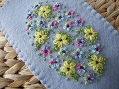 a close up of a piece of cloth with flowers on it and bead work