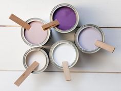 four paint cans with wooden sticks sticking out of them