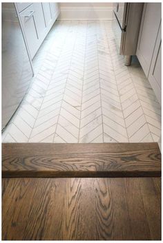 a kitchen with white cabinets and wood flooring on the floor, along with a wooden countertop