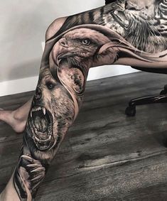 a man's leg with an eagle and bear tattoo on it