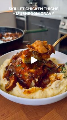 a bowl filled with mashed potatoes covered in sauce and meat on top of it