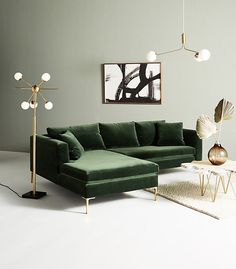 a living room with a green couch and two lamps on the wall, along with a white rug