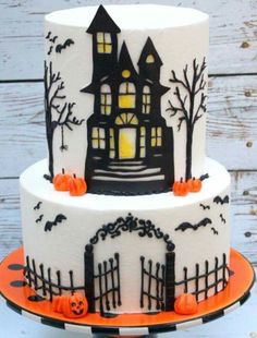 a three tiered halloween cake decorated with black and white icing, pumpkins and bats