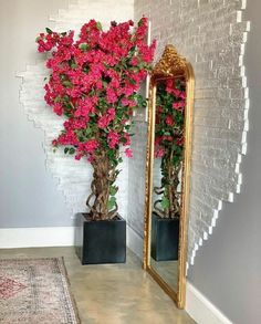 two vases with pink flowers in front of a mirror