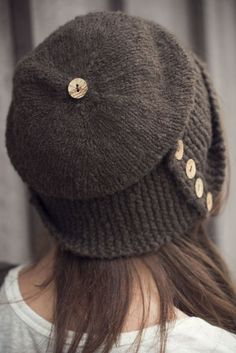 a woman wearing a brown knitted hat with buttons on the front and back of her head