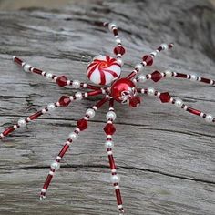 a spider made out of candy canes sitting on top of a piece of wood