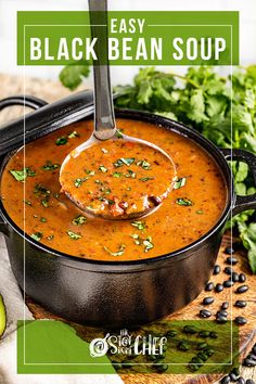 a spoon full of black bean soup on top of a cutting board with avocado