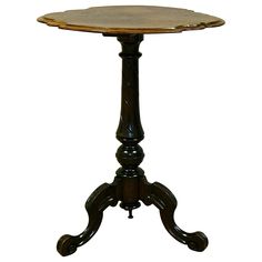 an old fashioned wooden table with two legs and a small round top on one end