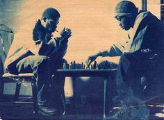 two men sitting at a table playing chess