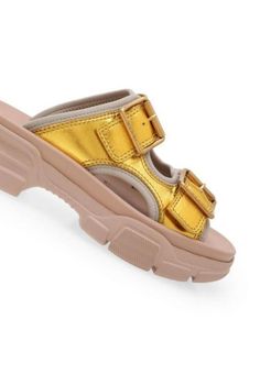 These Gucci leather sandals make a casual essential that's elevated with an outdoor-inspired vibe. This slide-sandal hybrid is designed with metallic double leather straps, a technical canvas lining, and a chunky, oversized rubber sole.Open toeBuckle fasteningChunky heel.Composition: Calf Leather 100%, Polyamide 100%Lining: Polyamide 100%, Polyurethane 100%Sole: Rubber 100%Made in Italy Trendy Gold Leather Sandals, Trendy Leather Slide Footbed Sandals, Leather Chunky Platform Open Toe Slides, Modern Chunky Platform Slide Sandals, Trendy Chunky Platform Slide Sandals, Luxury Slides With Textured Footbed For Spring, Luxury Platform Slides For Summer, Luxury Slide Mules For Spring, Luxury Summer Slide Mules